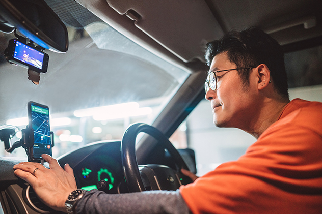 A driver using a mobile phone mounted in a cradle