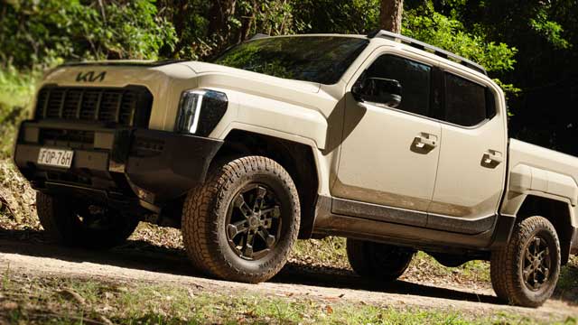 2025 Kia Tasman parked on a bush road