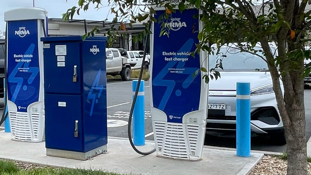A BYD Atto 3 parked at the Thrumster NRMA EV charger with tree foliage hanging in front