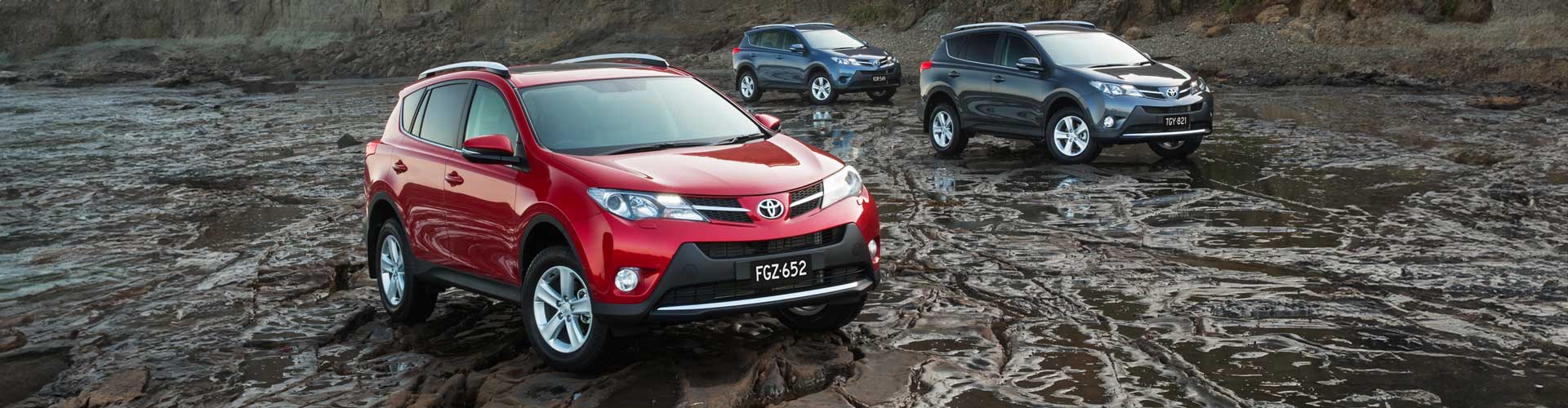 Red Toyota RAV4 parked in mud