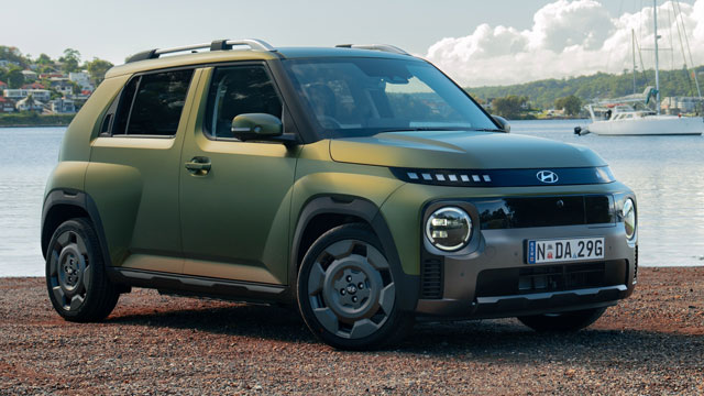 Metallic green 2025 Hyundai Inster Cross parked in front of marina