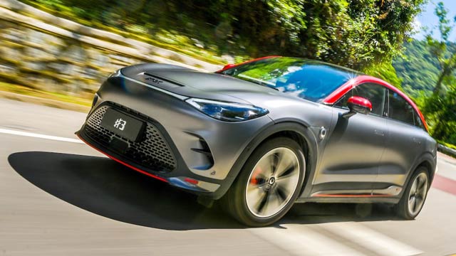 A front angle view of a two-tone dark silver with red accent Smart #3 Brabus on the road