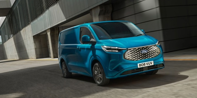 A blue 2022 Ford E-Transit Custom parked beside a modern corporate building