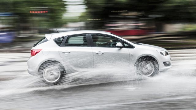 Car driving on a wet road at high speed