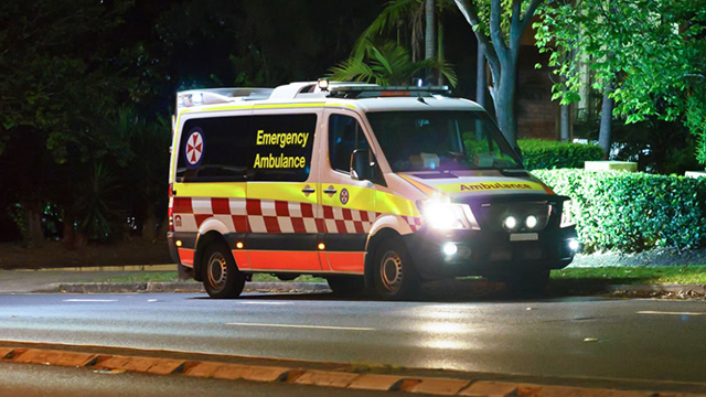 An ambulance on a road at night