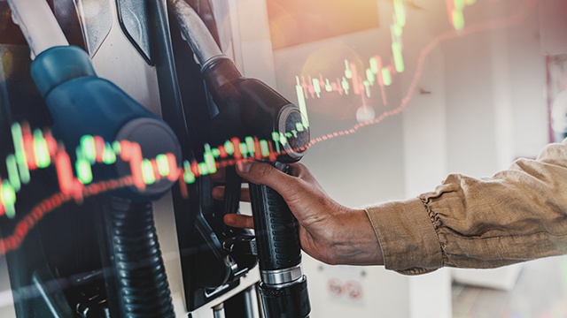 Hand on fuel pump with a graphic overlay of a bar chart graphic