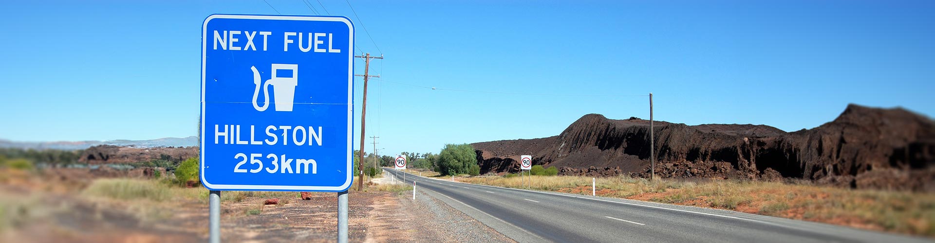 A sign on a country road warns of a 253km distance to next fuel stop in Hillston