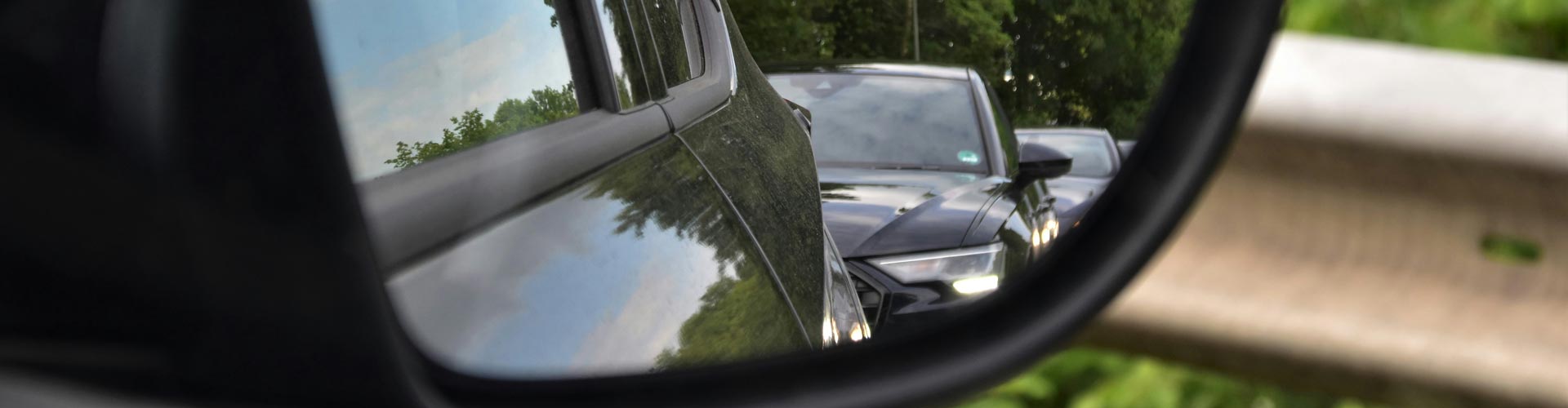 Car seen tailgating in side mirror of car in front