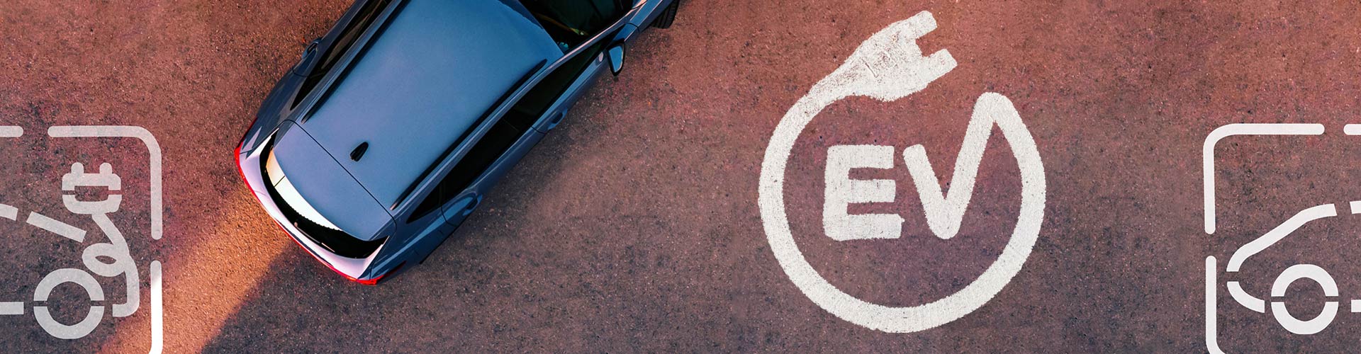 Aerial shot of a blue car and EV marking on the floor