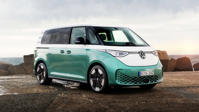 Angled side view of a green VW ID Buzz parked on a mountainside dirt road.