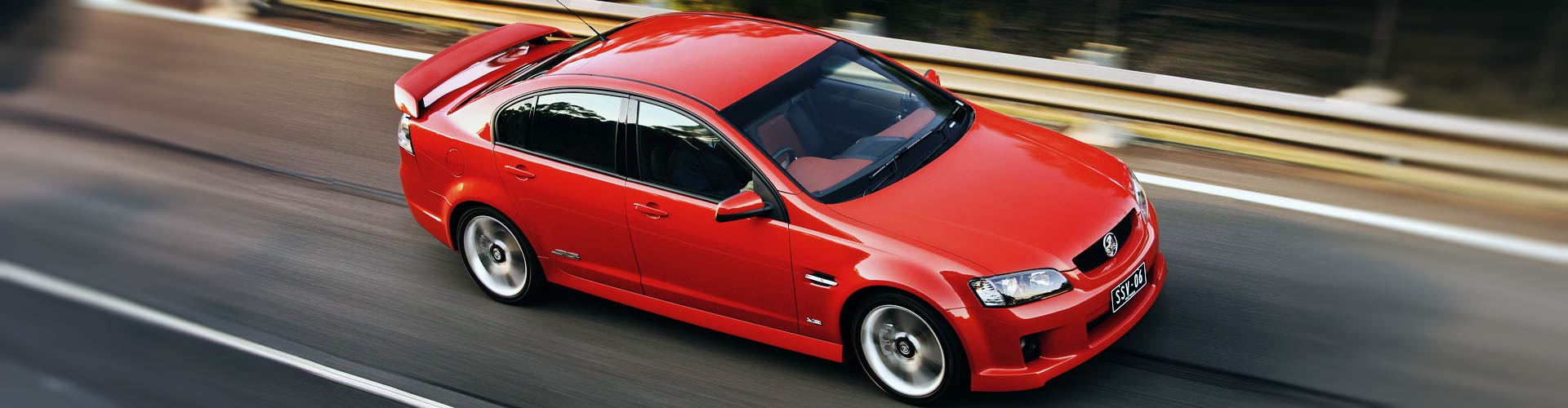 Dark orange 2007 Holden Commodore VE SS V8 driving on a road