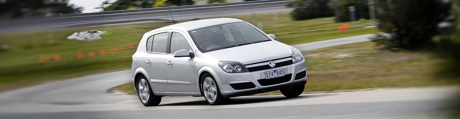 A white 2007 Holden Astra driving around a corner