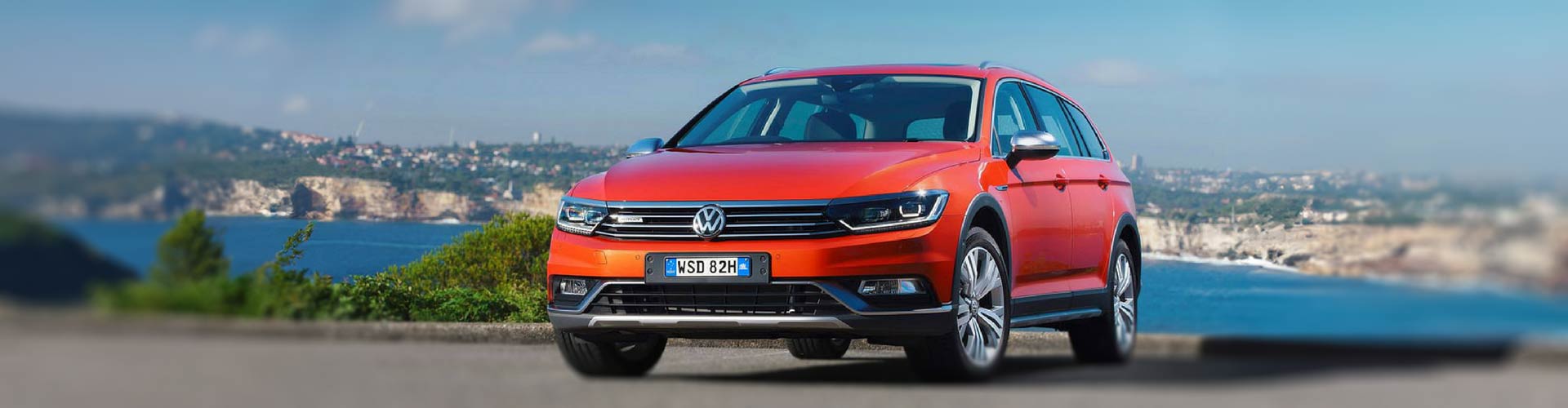 Red 2016 Volkswagen Passat Alltrack with harbour view behind