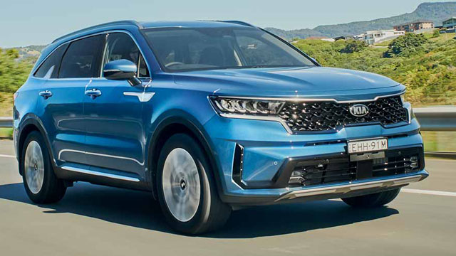 Blue 2020 Kia Sorento driving on a road past some trees