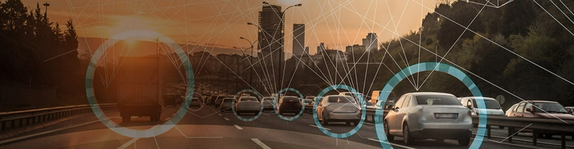 Cars driving on highway towards a city background.