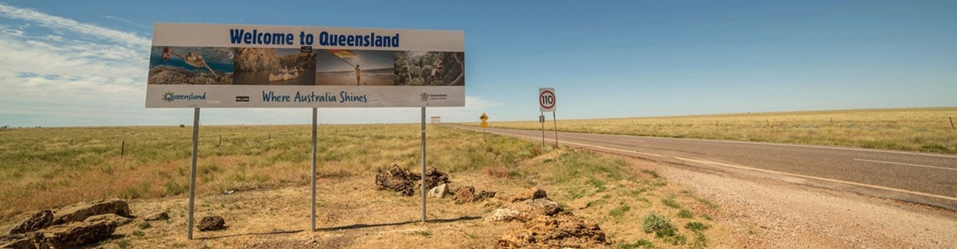 A Welcome to Queensland sign beside the highway