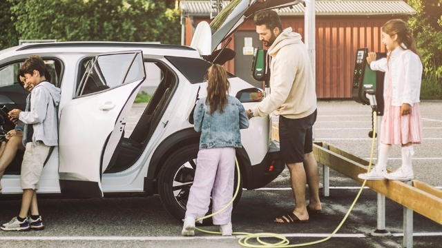 A family with their EV at a public charging station