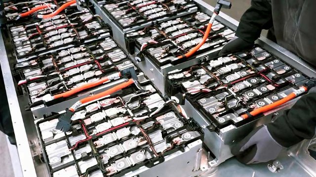 Someone inspecting the inside of an EV battery