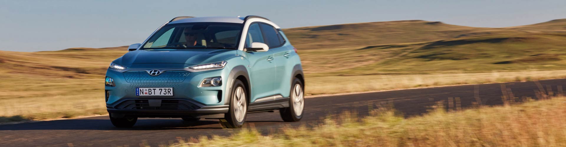 Blue 2019 Hyundai Kona Electric driving on a country road
