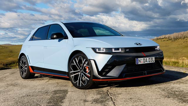 Blue 2024 Hyundai Ioniq 5 N driving on a road in the country