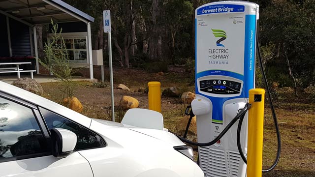 A white EV plugged into an EV charger in a bush setting at Derwent Bridge Tasmania