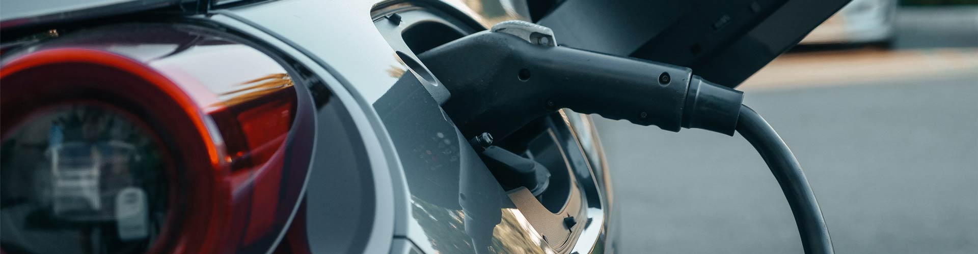 EV charging cable plugged into a grey electric car