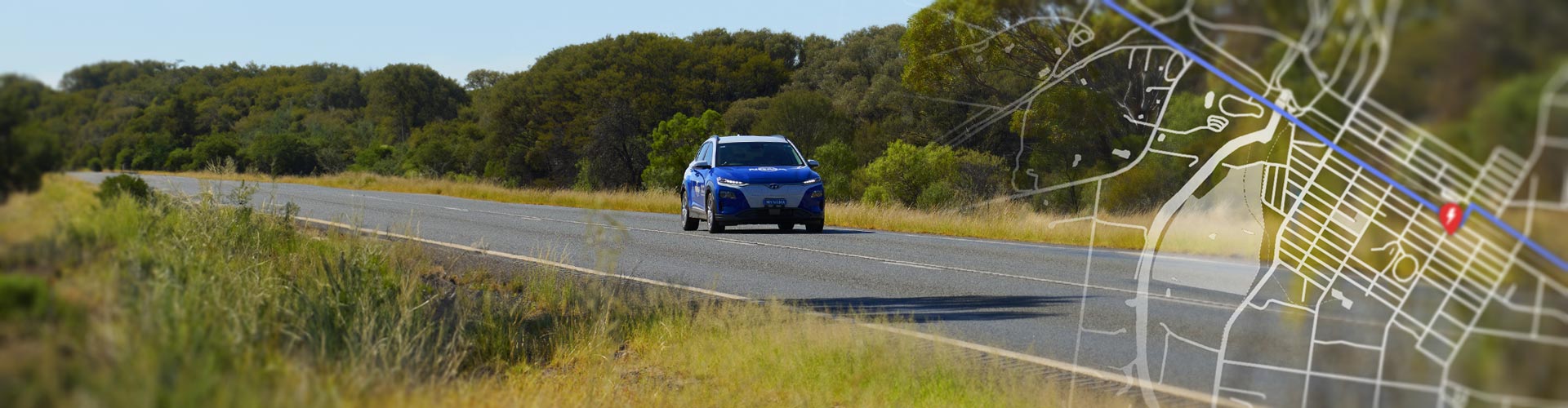 A transparent street map overlays a photo of a blue NRMA-branded Kona Electric driving on a country road