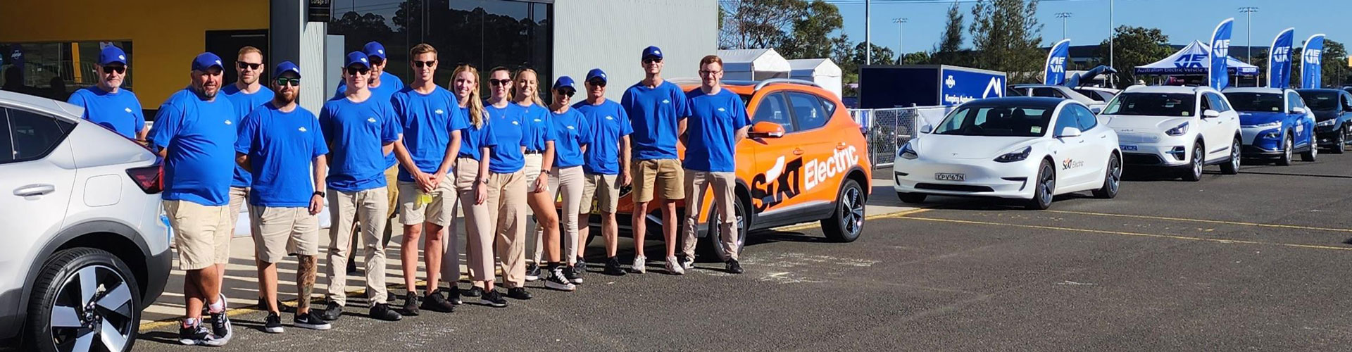 A group of people in blue shirts at an NRMA EV Drive Day in 2023