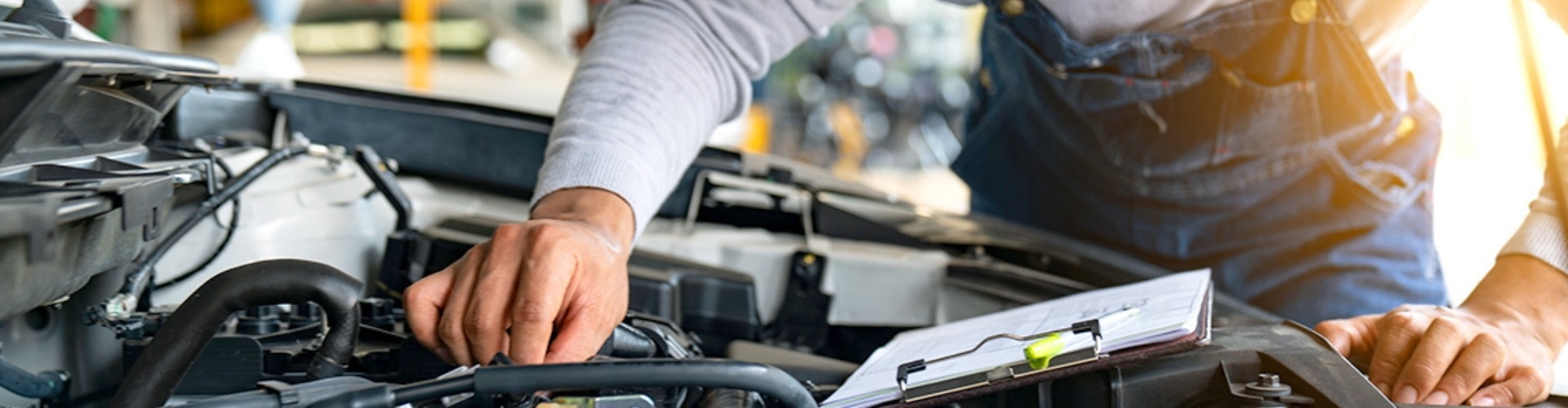 A technician inspects a vehicle's engine