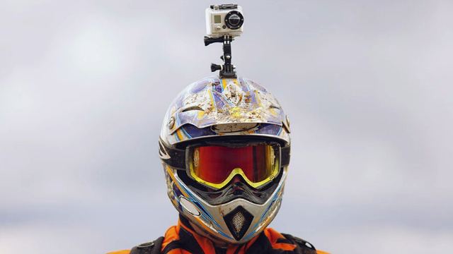 Motorcyclist wearing a helmet with a camera attached