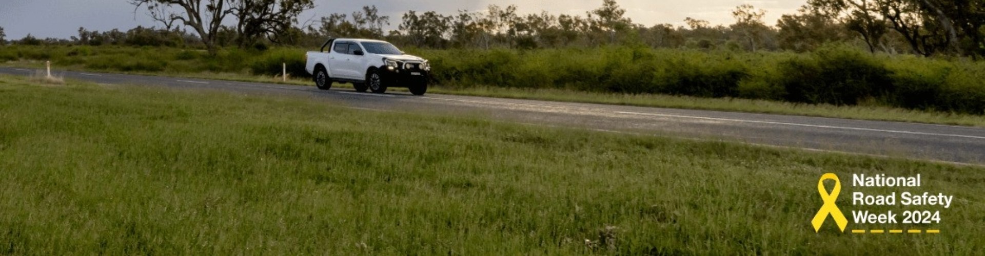 A photo of a country road with the National Road Safety Week logo