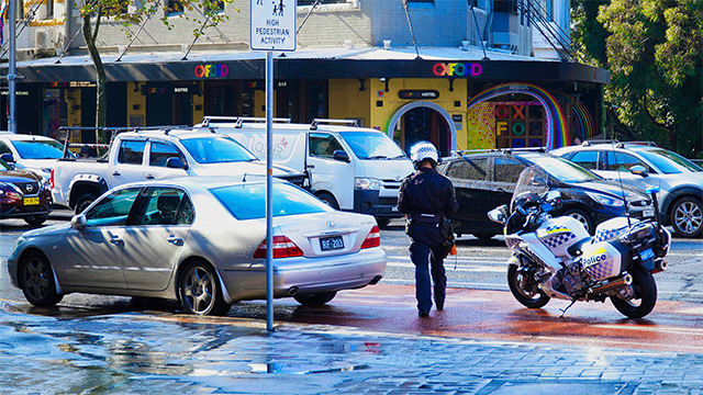 Police officer performing a traffic stop on a busy city street