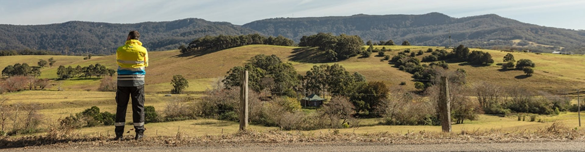 An SES worker looks out over rural landscape