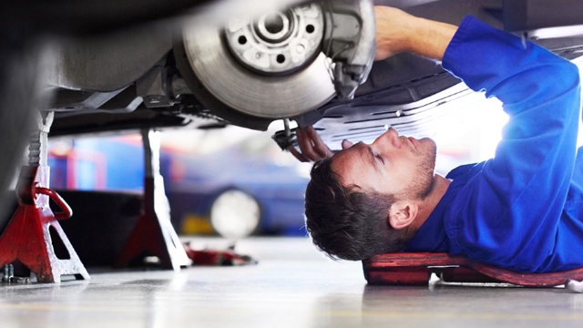 A mechanic working beneath a car