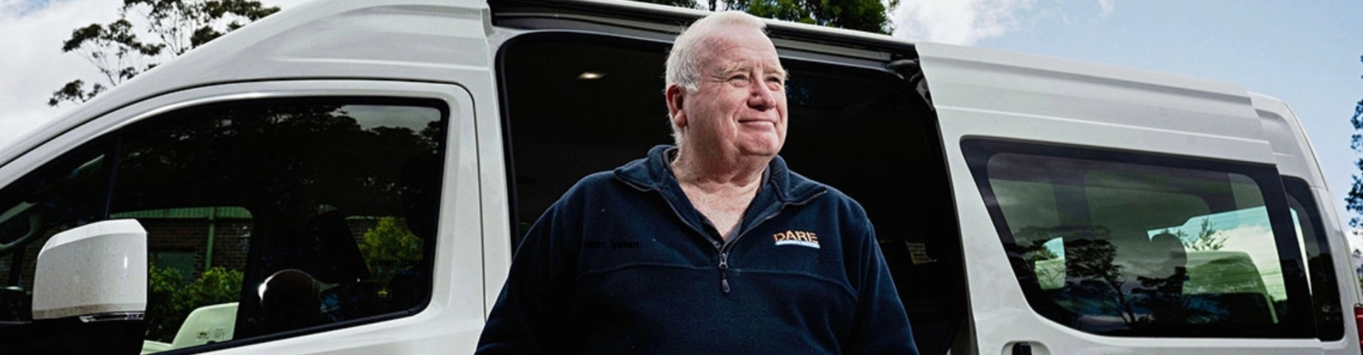 A business owner stands by their work van