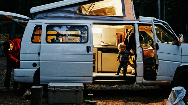 A father and child using a campervan at night