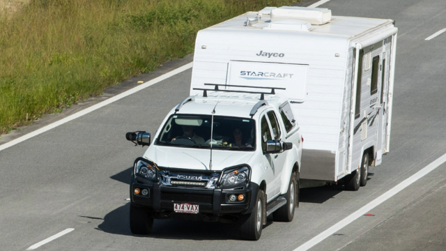 An SUV towing a caravan on an open road