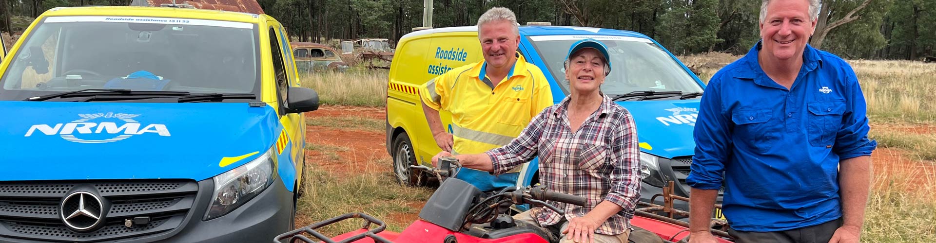 Three people outdoors, smiling at the camera.