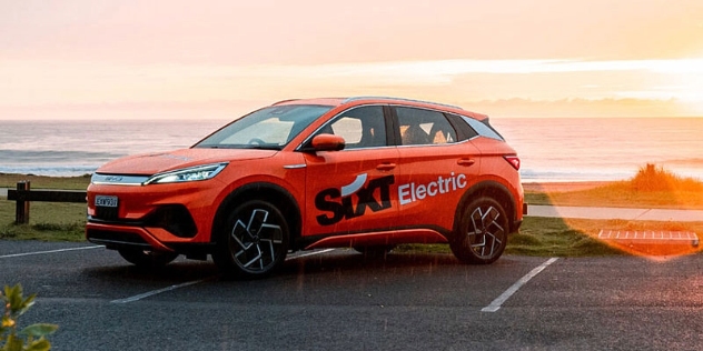 A Sixt-branded BYD EV parked by the sea