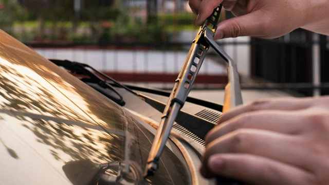 A man's hands lift a windscreen wiper