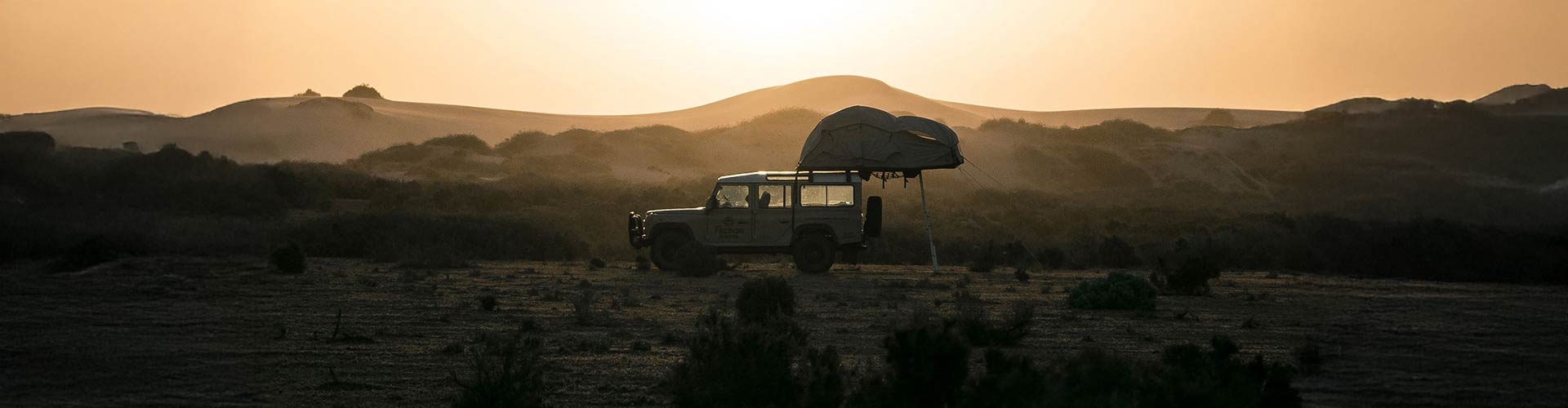 4WD setting up camp overlooking the sand dunes near Mungo National Park.