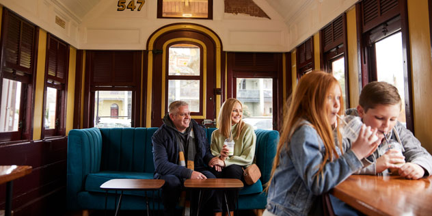 A family sit in a scenic historic railway carriage