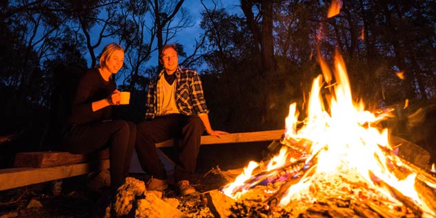 Couple by their campfire at Balor Hut Campground in Warrumbungle National Park.