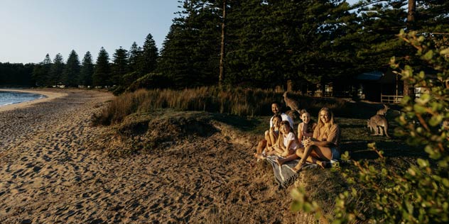 Family sitting together, watching the sun rise over the beach at Murramarang Beachfront Holiday Resort