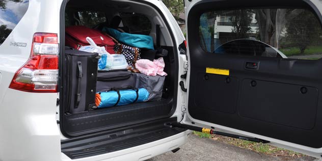 An SUV with boot open full of luggage