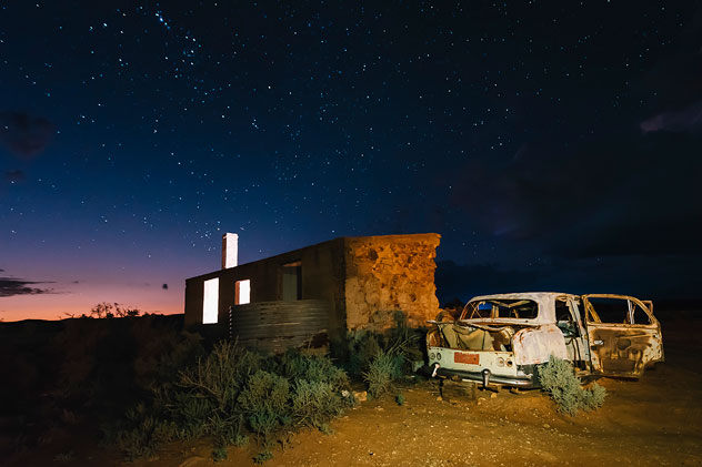 Old building ruin and abandoned car in the desert at night in Silverton near Broken Hill
