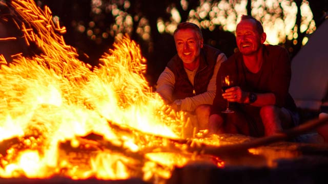Two men camping by fire