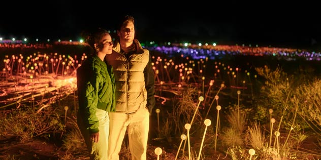 A couple standing amongst night lights at Ulurua
