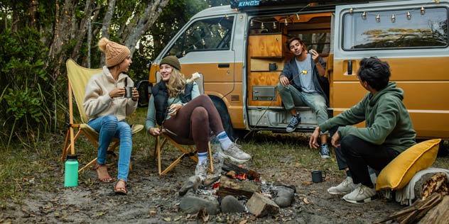 Young people relaxing by the campfire at Waves Campground in Crescent Head