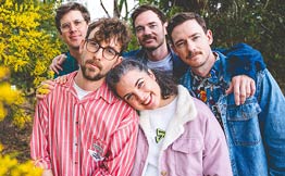 Group of people standing close together in pink and blue shirts
